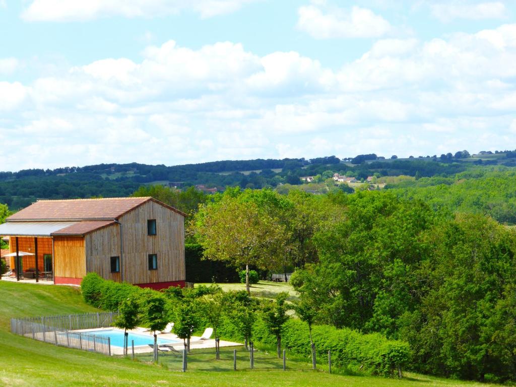 eine Scheune mit Pool und Bäumen in der Unterkunft les gîtes de fred en Dordogne, Maisons avec piscines privées et chauffées in Florimont-Gaumiers