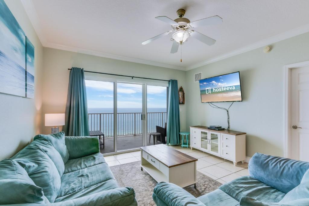 ein Wohnzimmer mit einem Sofa und einem Flachbild-TV in der Unterkunft Crystal Shores West 202 in Gulf Shores