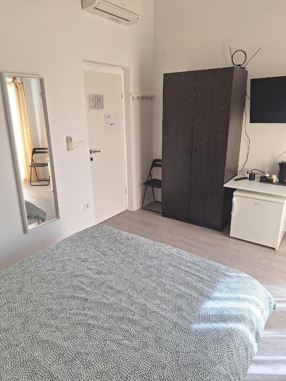 a bedroom with a bed and a mirror and a cabinet at Pension Oaza in Hvar