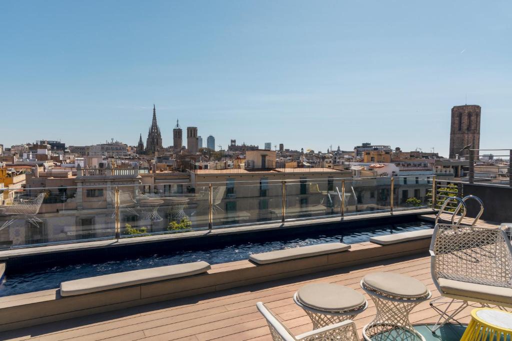 a balcony with chairs and a view of a city at Hotel Bagués, a Small Luxury Hotel of the World in Barcelona