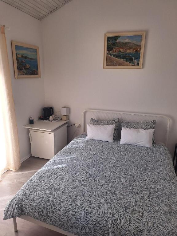 a white bedroom with a bed and a desk at Pension Oaza in Hvar