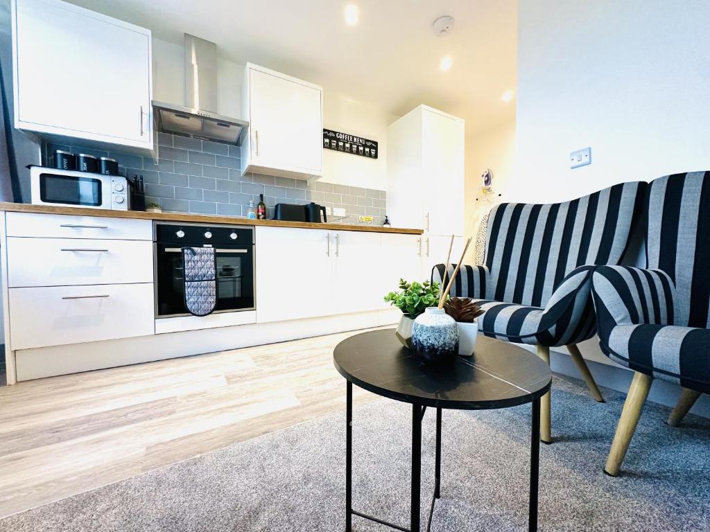 a living room with a table and a kitchen at 301 Grosvenor House in Wakefield