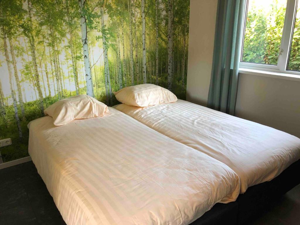 1 cama con 2 almohadas en una habitación con ventana en Landgoed Leudal, en Haelen