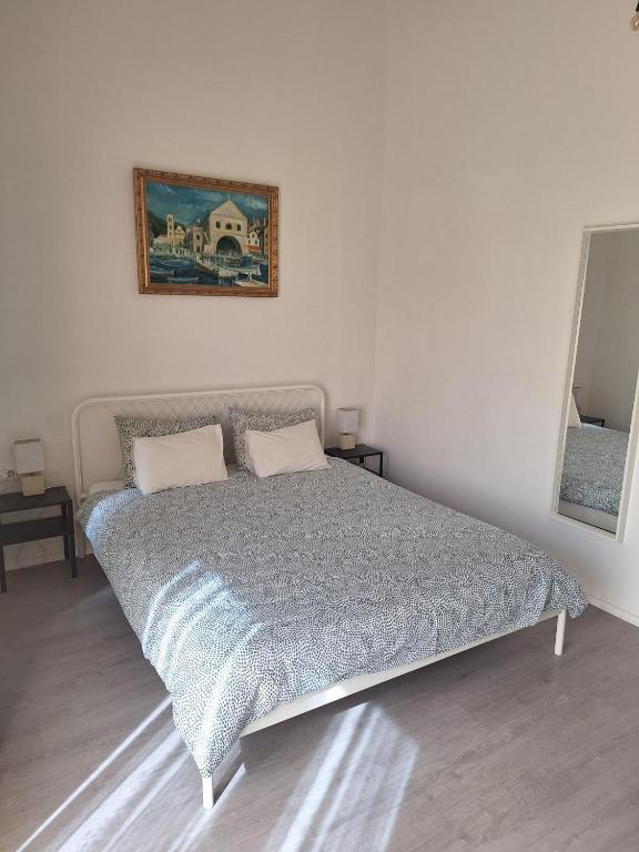 a bed in a bedroom with a picture on the wall at Pension Oaza in Hvar