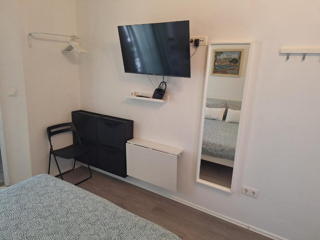 a room with a television on a wall with a mirror at Pension Oaza in Hvar
