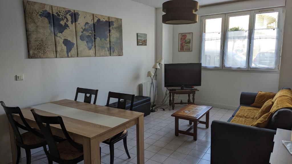 a living room with a table and a tv at Les tourelles in Dieppe