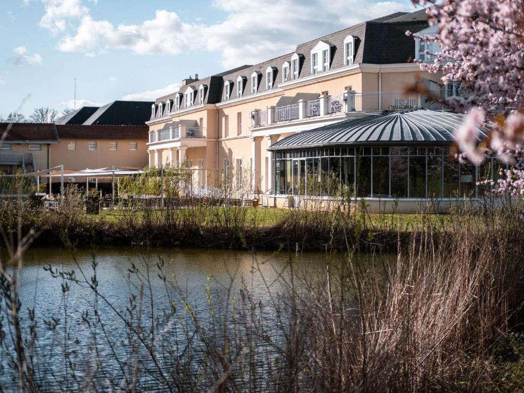 een groot gebouw naast een waterlichaam bij Mercure Chantilly Resort & Conventions in Chantilly