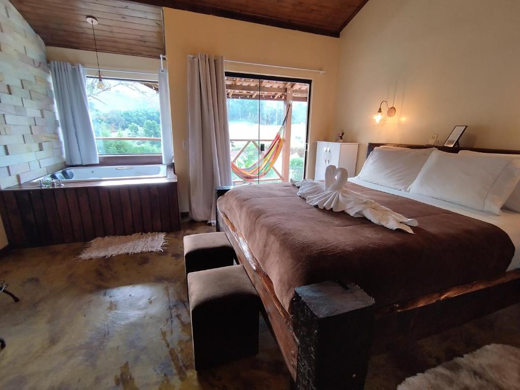 een slaapkamer met een groot bed en een groot raam bij Estação 160 in Santo Antônio do Pinhal