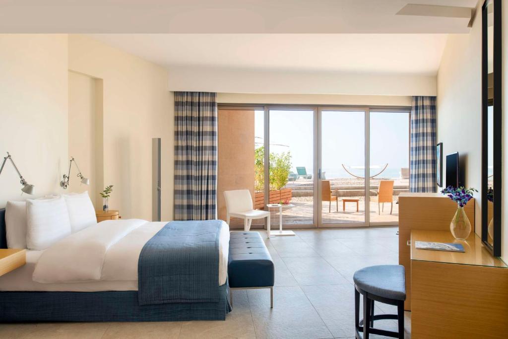 pokój hotelowy z łóżkiem i salonem w obiekcie Kempinski Hotel Ishtar Dead Sea w mieście Swemeh