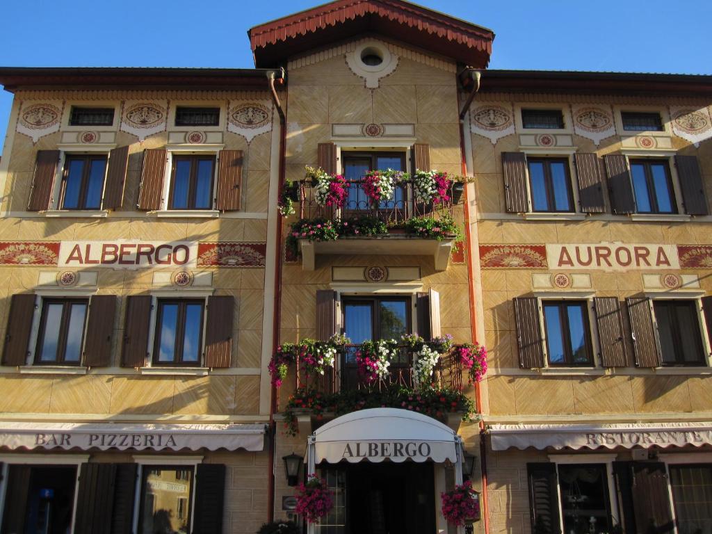 un edificio con balcones y flores en Hotel Aurora en Vallarsa