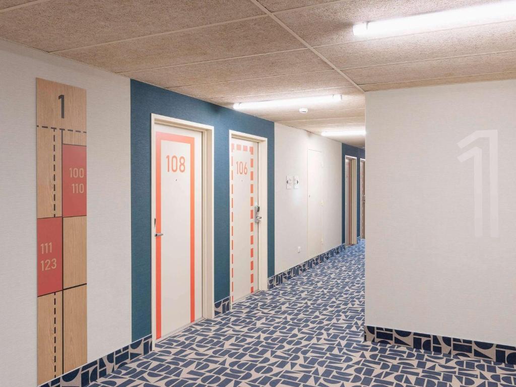 a hallway of an office with doors and tile floors at Ibis Budget Mont De Marsan in Mont-de-Marsan