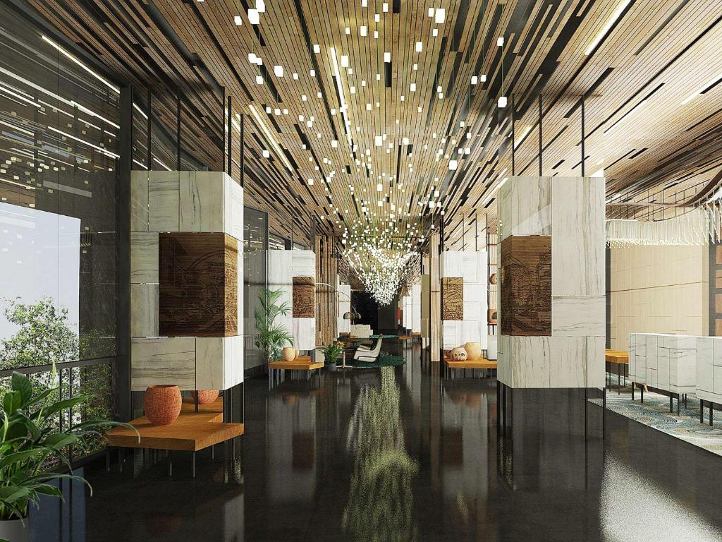 un gran vestíbulo con una gran lámpara de araña en un edificio en Mövenpick Hotel Jakarta City Centre, en Yakarta