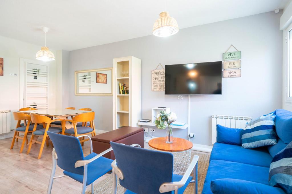 - un salon avec un canapé bleu et une table dans l'établissement Apartamentos Go - Chalet Calera, à Arroyo de la Encomienda