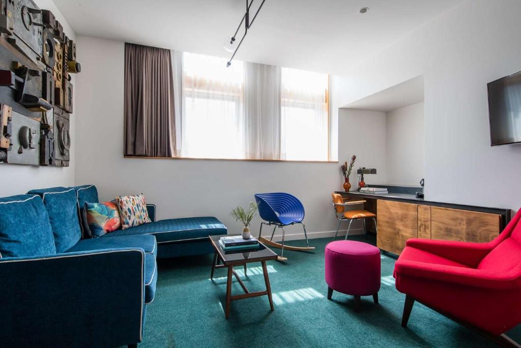 雪梨的住宿－The Old Clare Hotel, Independent Collection by EVT，客厅配有蓝色的沙发和椅子