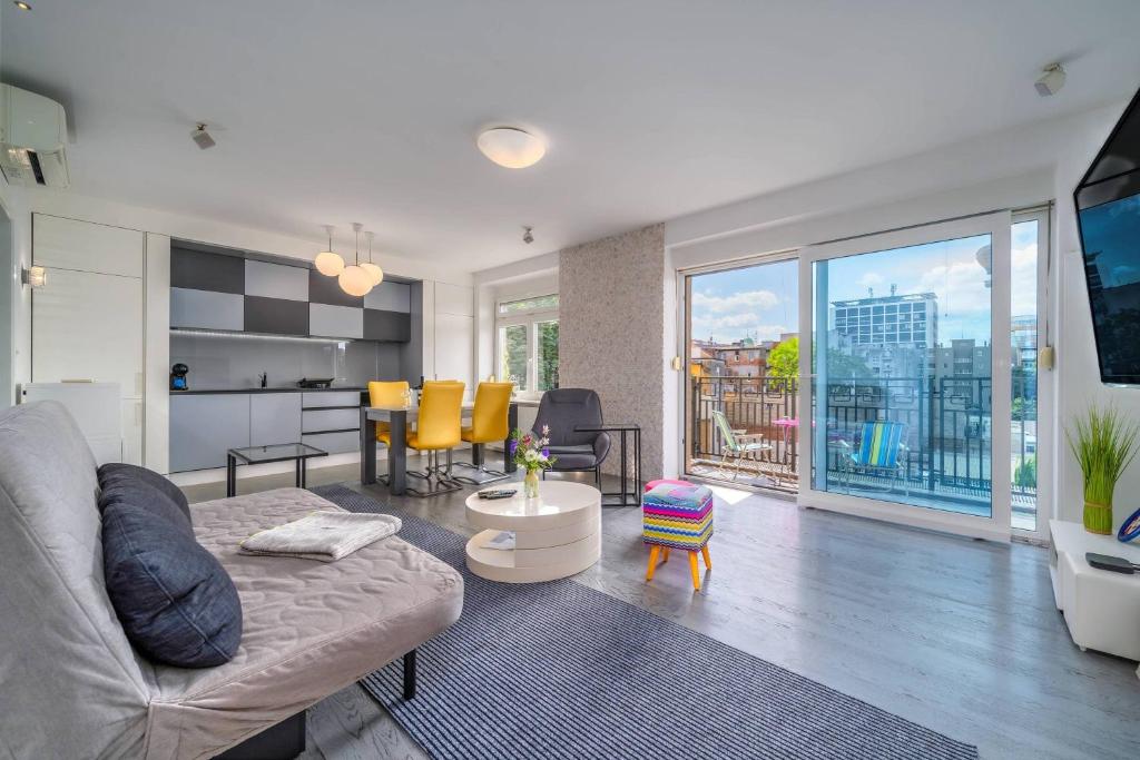 a living room with a couch and a view of a city at Silver Apartment With Hot Tub And Balcony - Happy Rentals in Zagreb