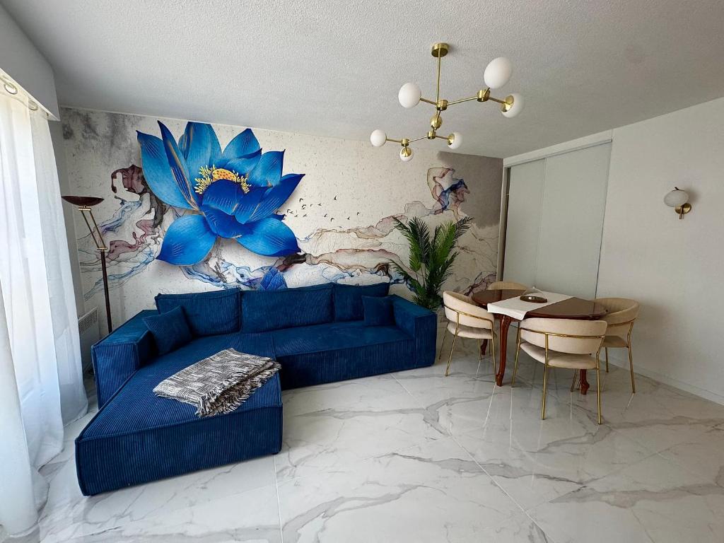 un salon avec un canapé bleu et une table dans l'établissement L'appartement Azur, à Nice