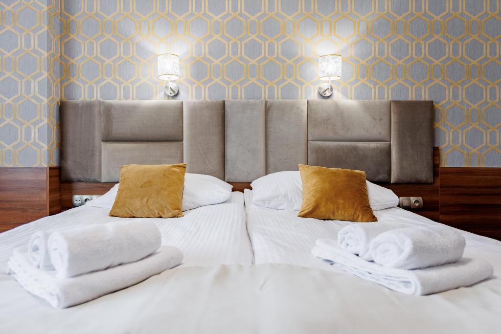 Un dormitorio con una cama blanca con toallas. en Hotel Cristal Park, en Dąbrowa Tarnowska