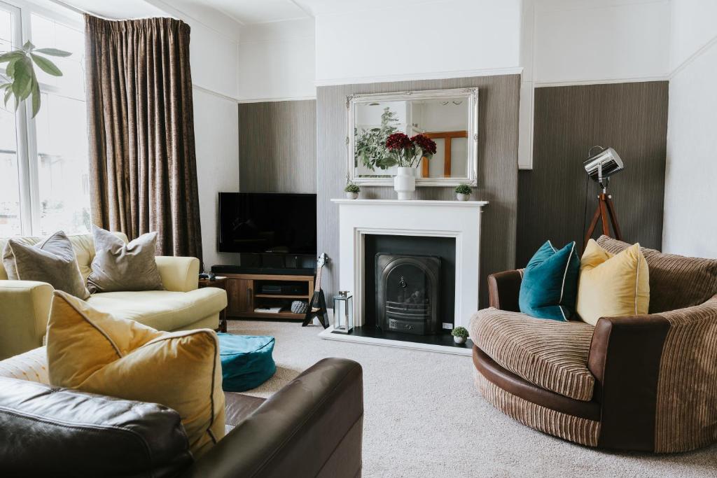 a living room with two couches and a fireplace at 3 Bed - Modern Comfortable Stay - Preston City Centre in Preston