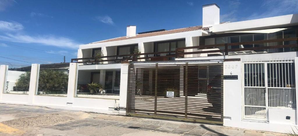 un edificio blanco con una puerta delante en Pousada Beira Mar - Suítes Frente ao mar, en Torres