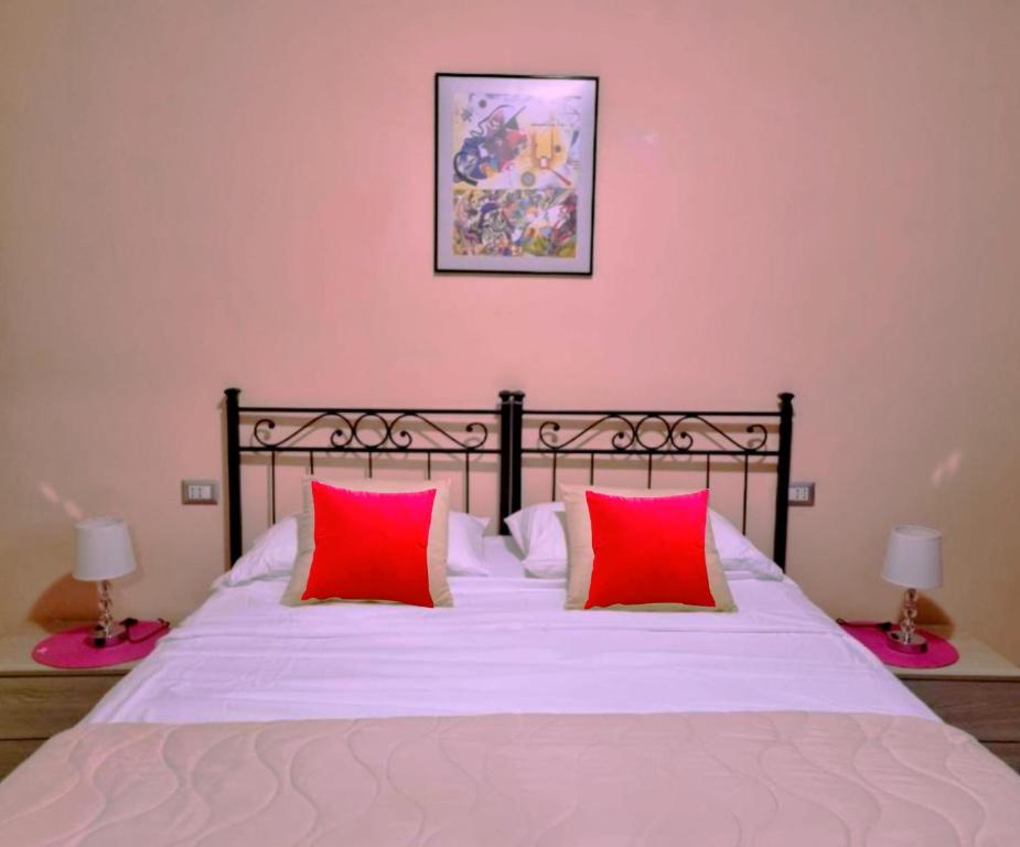 un letto con due cuscini rossi in una camera da letto di Sweet Dream a Passignano sul Trasimeno