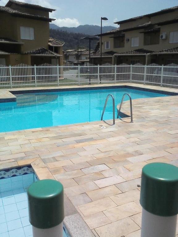 een groot zwembad met blauw water in een gebouw bij Linda casa em condomínio in Paraty