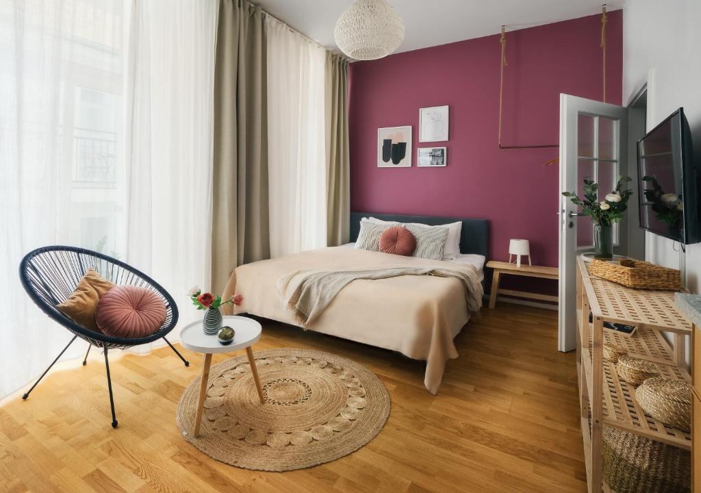 um quarto com paredes roxas e uma cama e uma cadeira em TurnKey I Downtown Studio em Praga