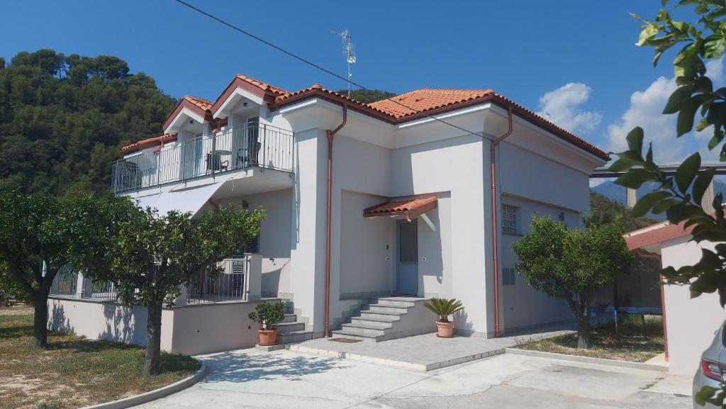 een groot wit huis met een balkon bij La casa al mare di MatiGiò in Pietra Ligure