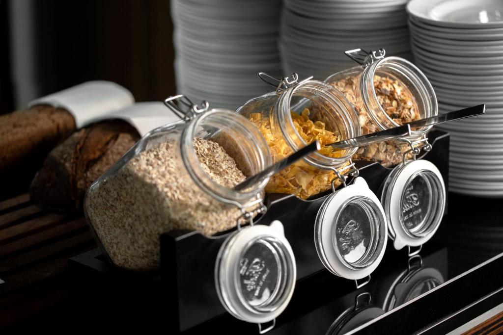 a buffet with several glass jars of food and bread at Wakeup - Aarhus in Aarhus