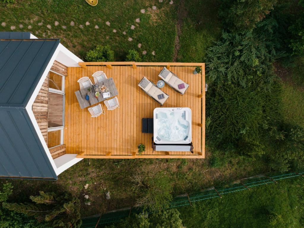 an overhead view of a wooden deck with chairs and a bathtub at Hegyi Kabin - Zebegény in Zebegény