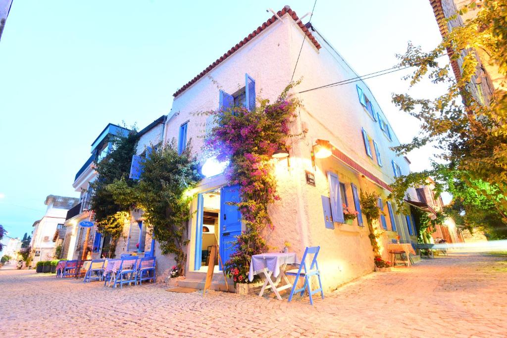 uma rua com mesas e cadeiras em frente a um edifício em Sulty's Alaçatı em Izmir