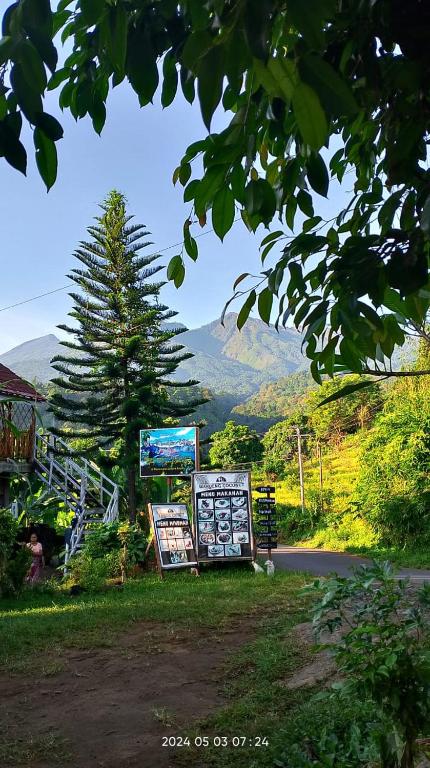 a sign on the side of a road with a mountain at Blue Mountain Cottage in Senaru
