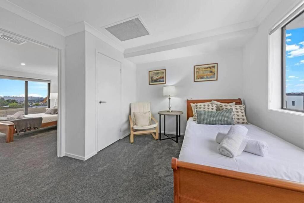 - une chambre blanche avec un lit et une fenêtre dans l'établissement Brand New Home In Oran Park, à Narellan