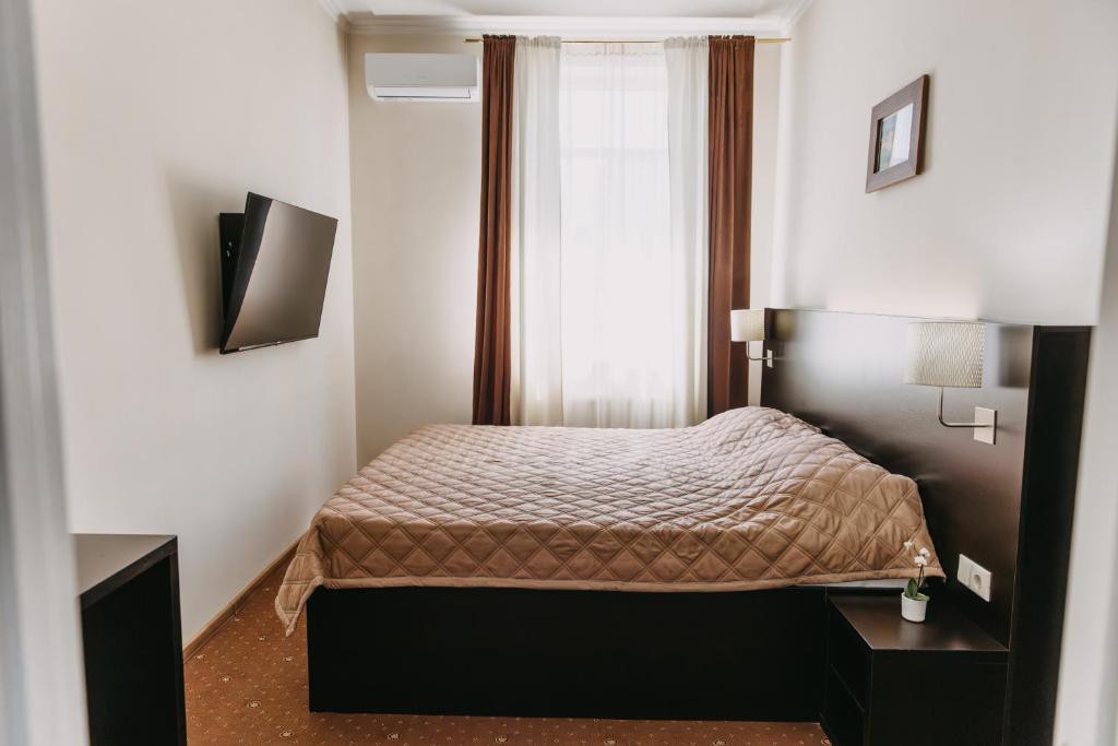 - une petite chambre avec un lit et une fenêtre dans l'établissement Summit Villa, à Chişinău
