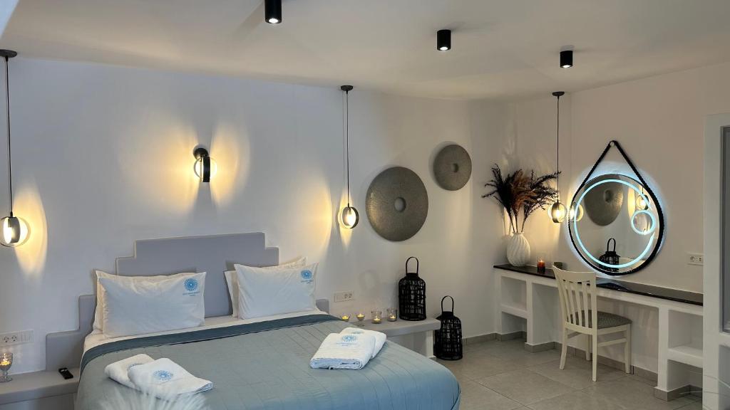 佩里薩的住宿－Santorini Miracles Suites，一间卧室配有一张带镜子的床和一张书桌