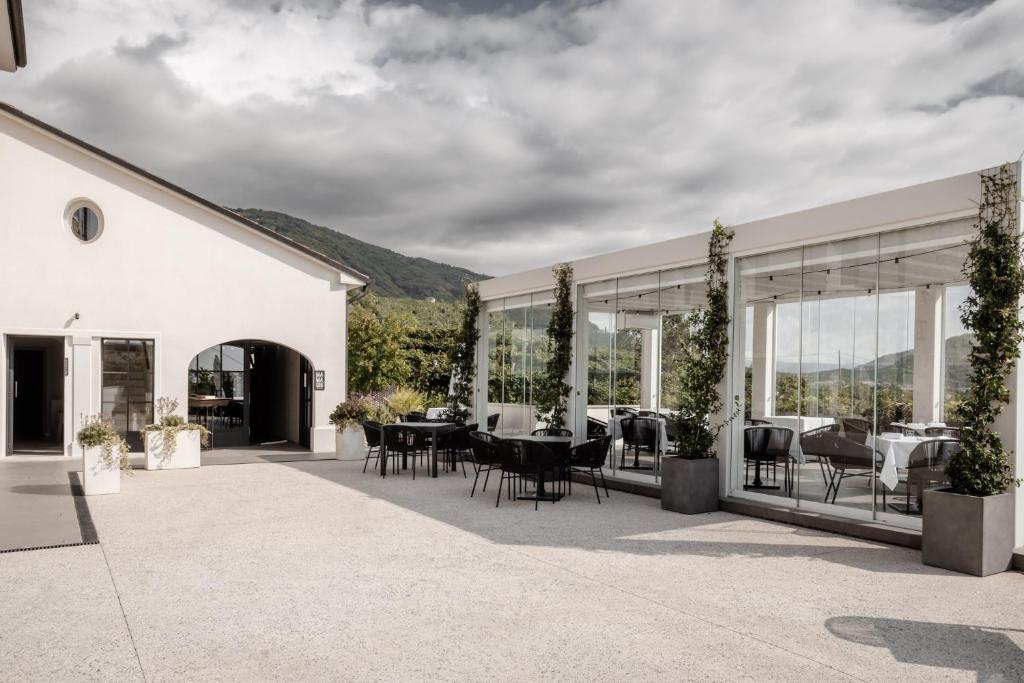 a patio with tables and chairs on a building at Locanda MaMaGiò in Valdobbiadene