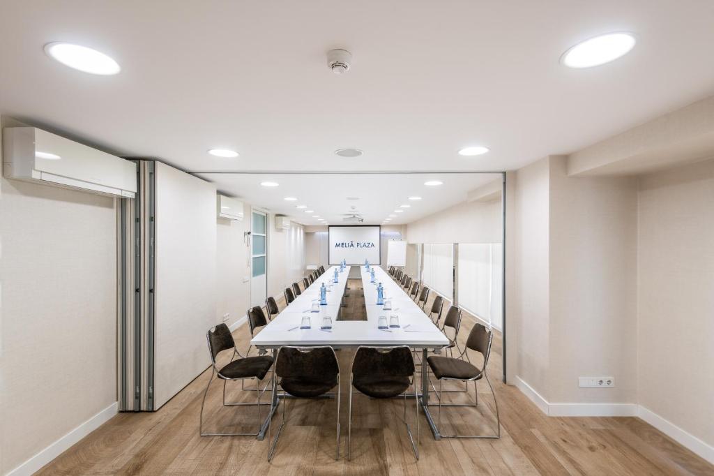a long conference room with a long table and chairs at Melia Plaza Valencia in Valencia