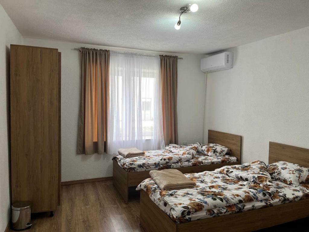 a bedroom with three beds and a window at Lejla's guesthouse in Gusinje