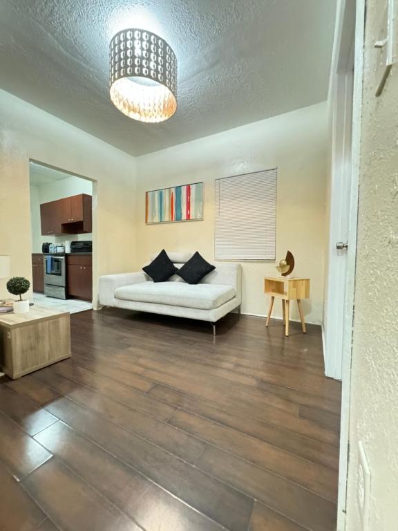 ein Wohnzimmer mit einem weißen Sofa und einem Tisch in der Unterkunft Oasis Wynwood in Miami
