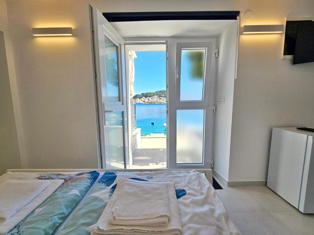 a bedroom with a bed with a view of the ocean at Apartman Velopin in Mali Lošinj