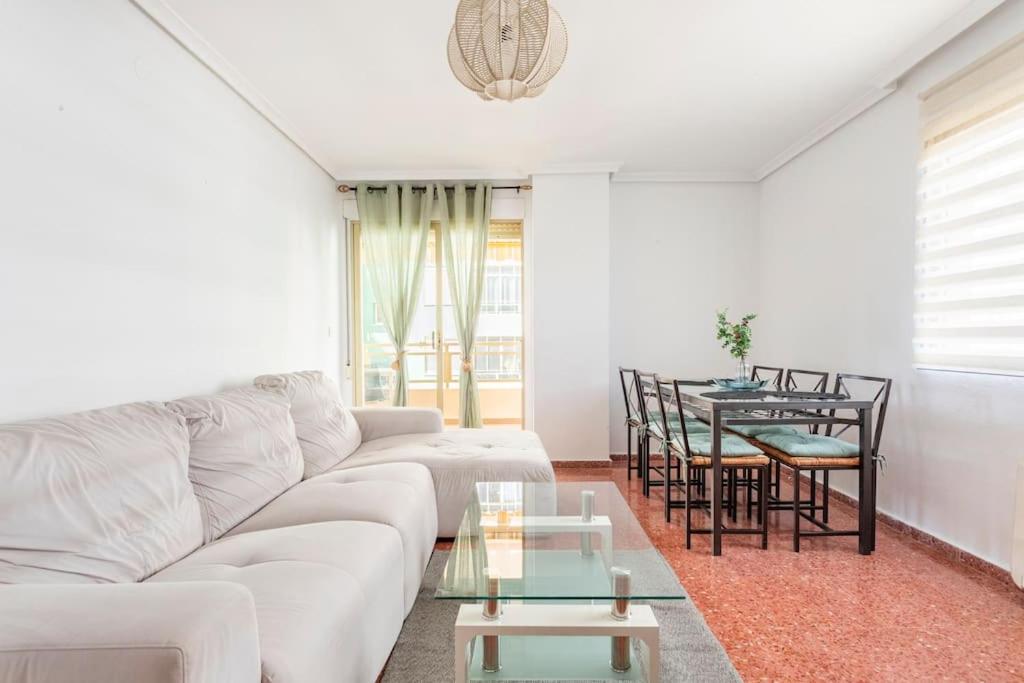 a living room with a white couch and a table at Villamar playa wifi y garaje in Cullera