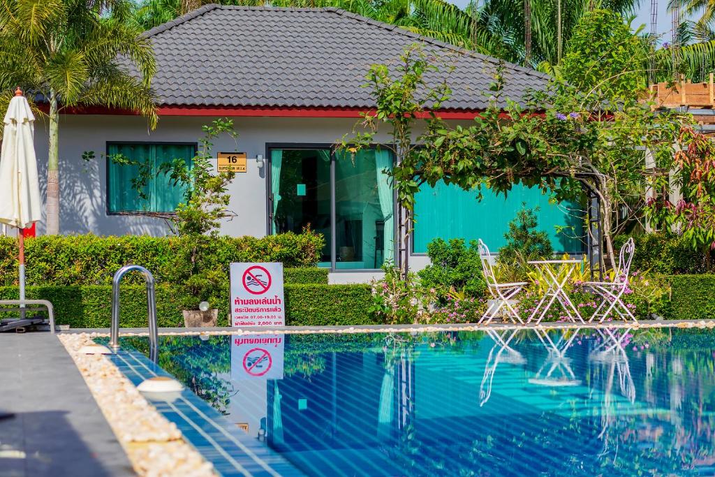 a swimming pool with a no swimming sign next to a house at Neenlawat Riverside in Suratthani
