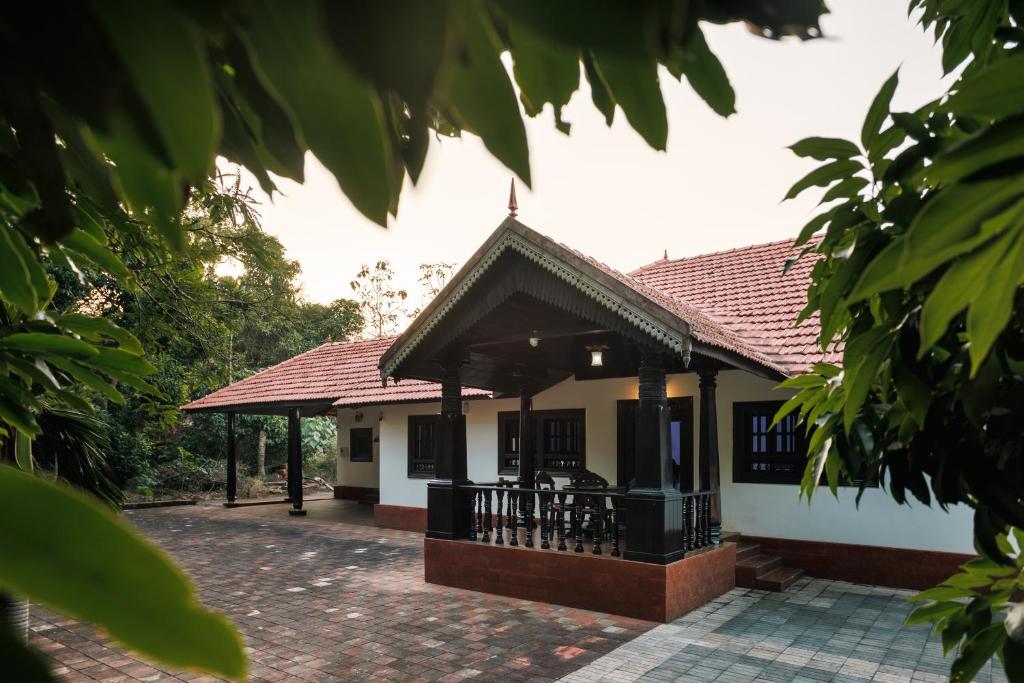 a small house with a roof at Ashriel Farm House by EWA Properties in Kankanādi