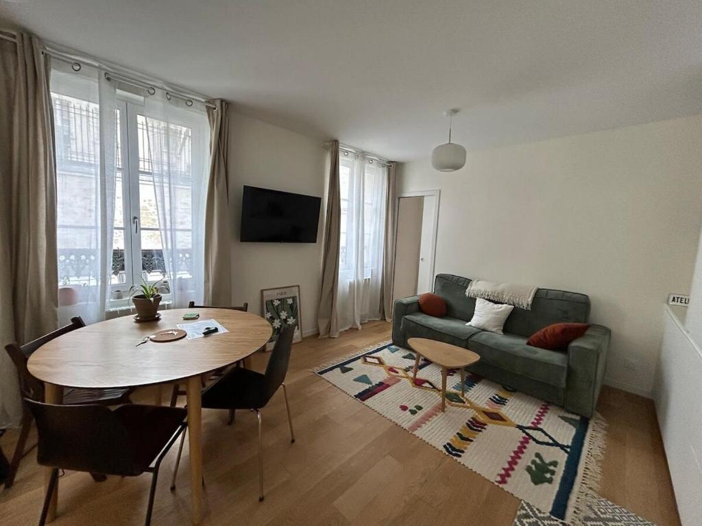 un salon avec une table et un canapé dans l'établissement One bedroom Temple - CityCosy, à Paris
