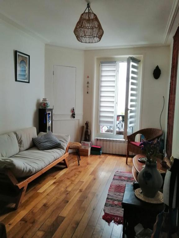 - un salon avec un canapé et du parquet dans l'établissement Appt Letort CityCosy, à Paris
