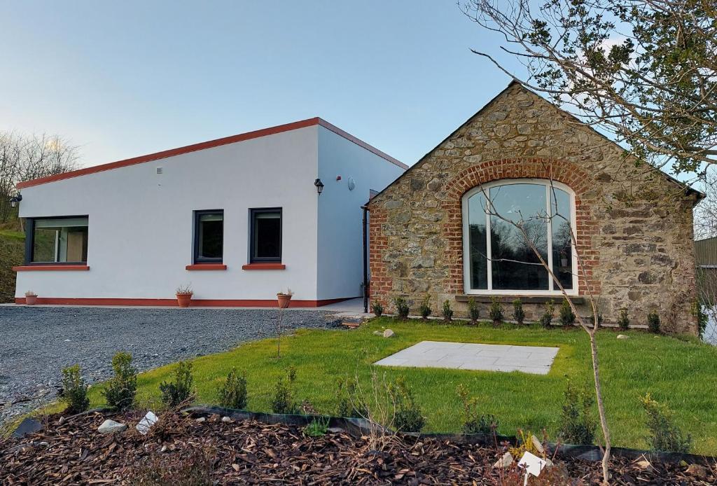 een wit huis met een stenen gevel bij The Haggard Self Catering Accommodation in Castleblayney