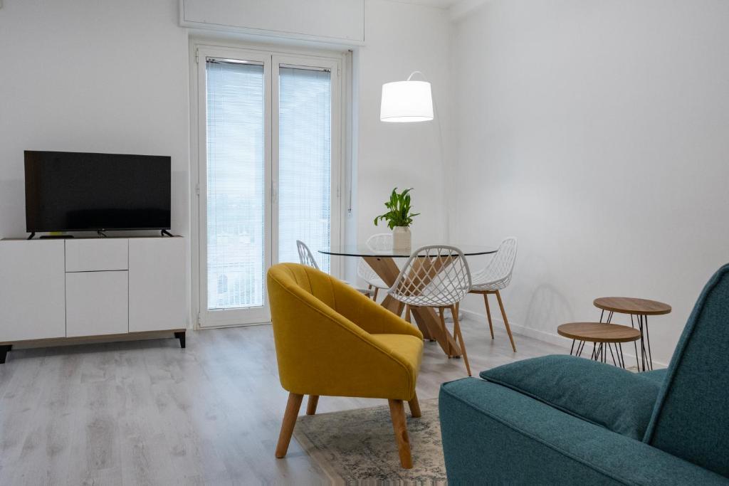 a living room with a tv and a table and chairs at Casa Mila in Milan