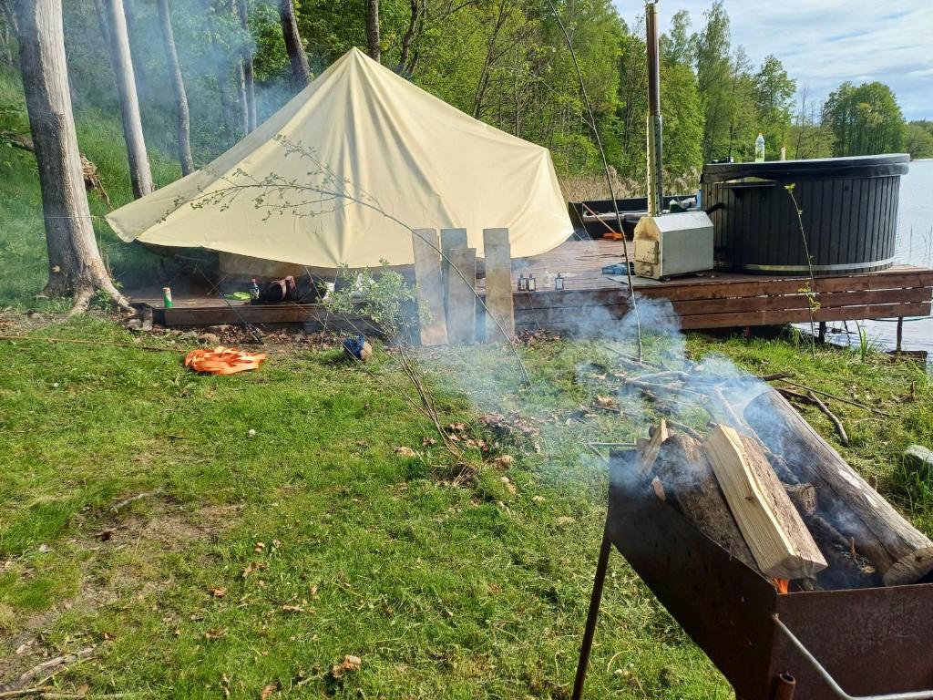 a tent is set up on a dock with smoke at Pelakys Glamping Lounge in Šlepečiai