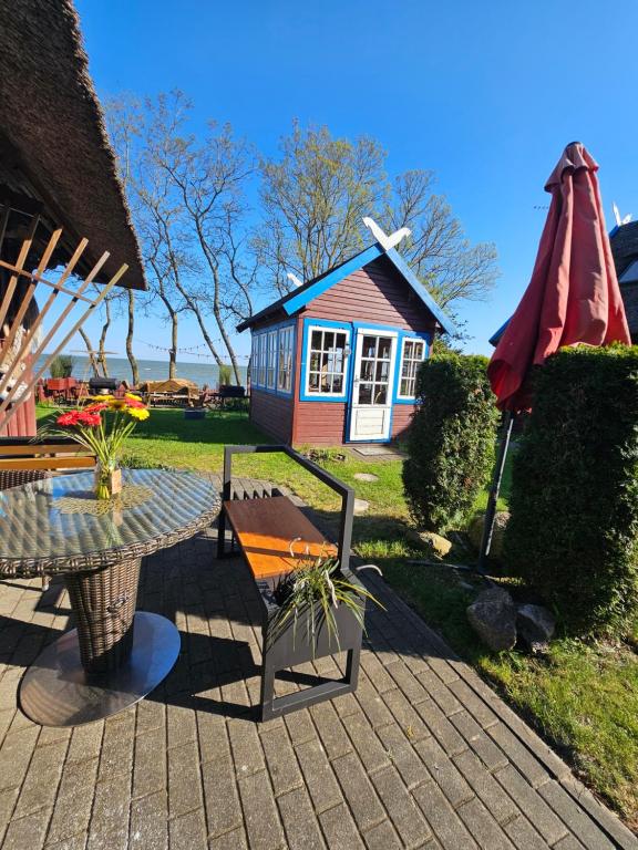 a patio with a table and a small house at Preila Kristina -1 in Neringa