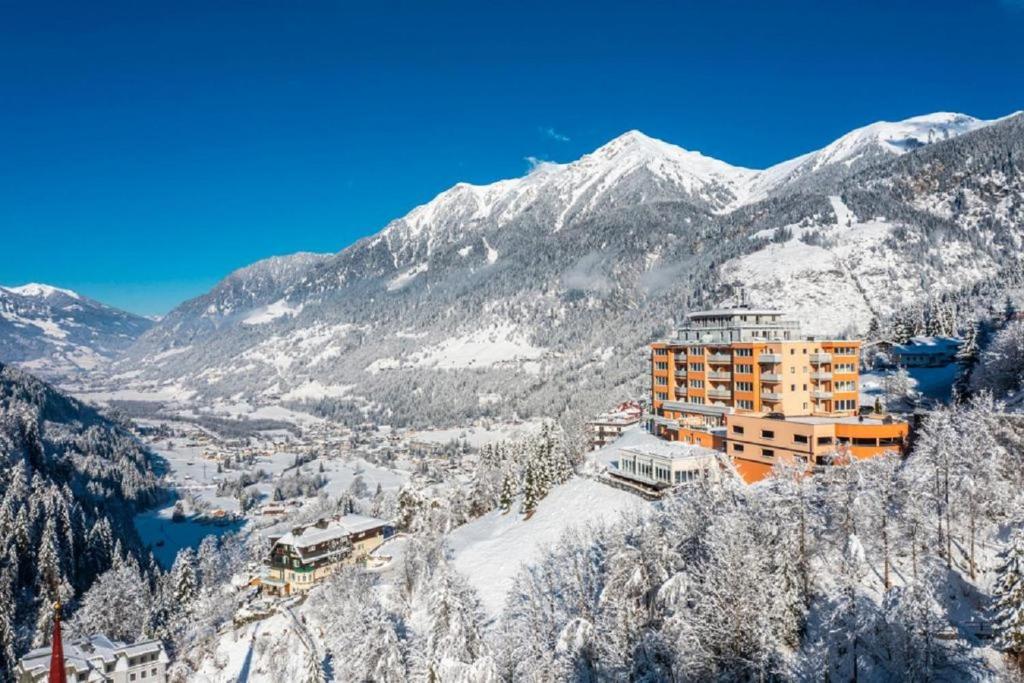 a building on a mountain with snow covered mountains at Exclusive Panorama Spa Suiten DAS SCHILLER in Bad Gastein