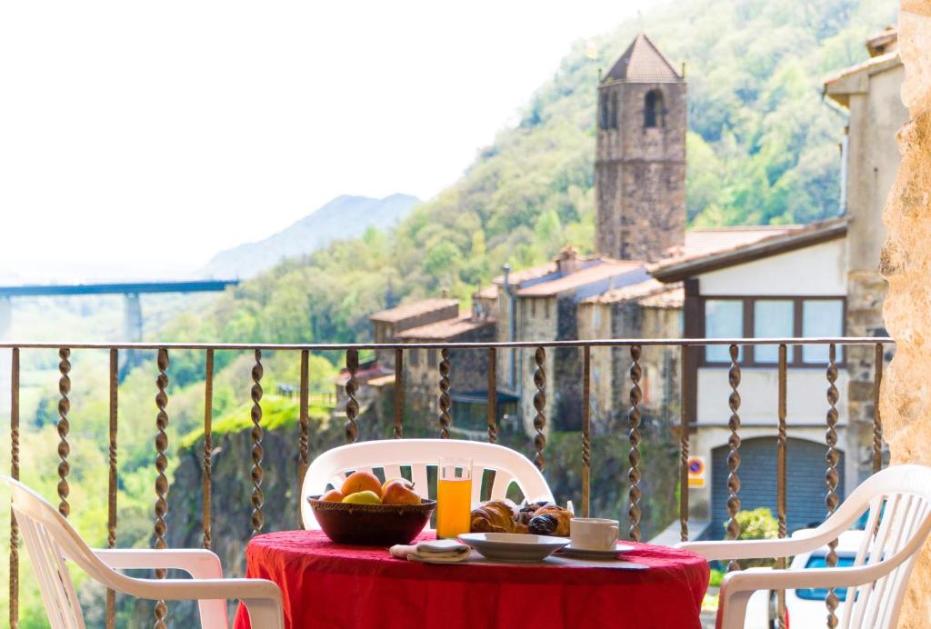 a table with a bowl of fruit on a balcony at Can Castell in Castellfollit de la Roca